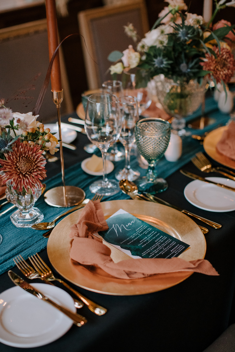 A solid gold charger plate is the perfect pop of color to warm moodier color palettes. Also a great option in darker venue spaces.